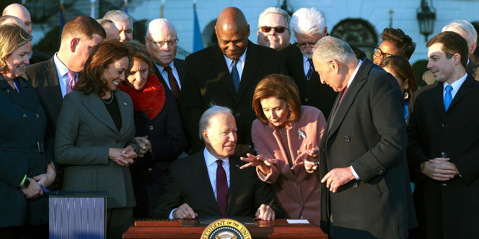President Joe Biden signs the infrastructure bill at the White House as he is surrounded by lawmakers, Cabinet members and other allies, including AFSCME President Lee Saunders. (Photo by Alex Wong/Getty Images)